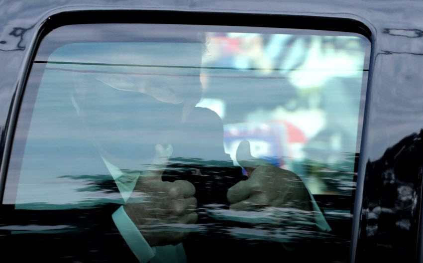 Tổng thống Trump đeo khẩu trang, giơ hai ngón tay cái trong ô tô chạy ngoài bệnh viện - ảnh: Reuters