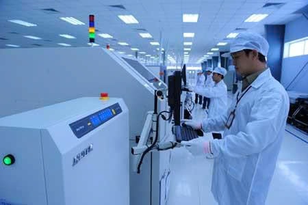 Các kỹ sư đang vận hành dây chuyền sản xuất thiết bị điện tử viễn thông