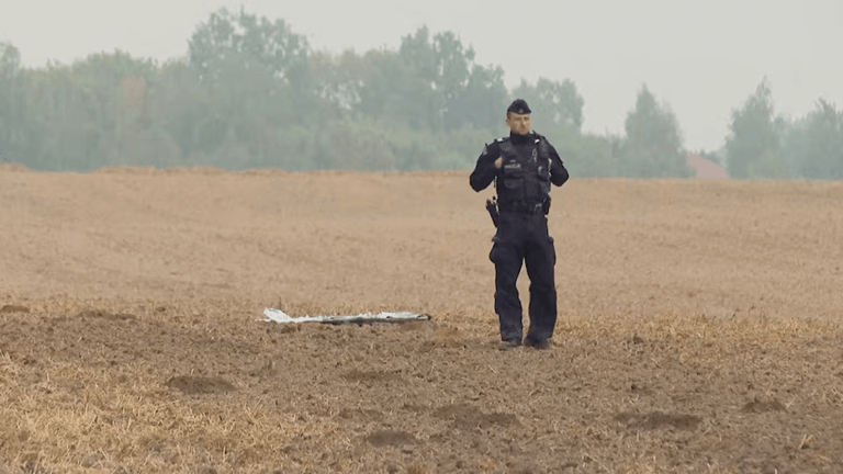 Một cảnh sát Ba Lan đứng gần một mảnh vỡ UAV. Polsat News qua REUTERS