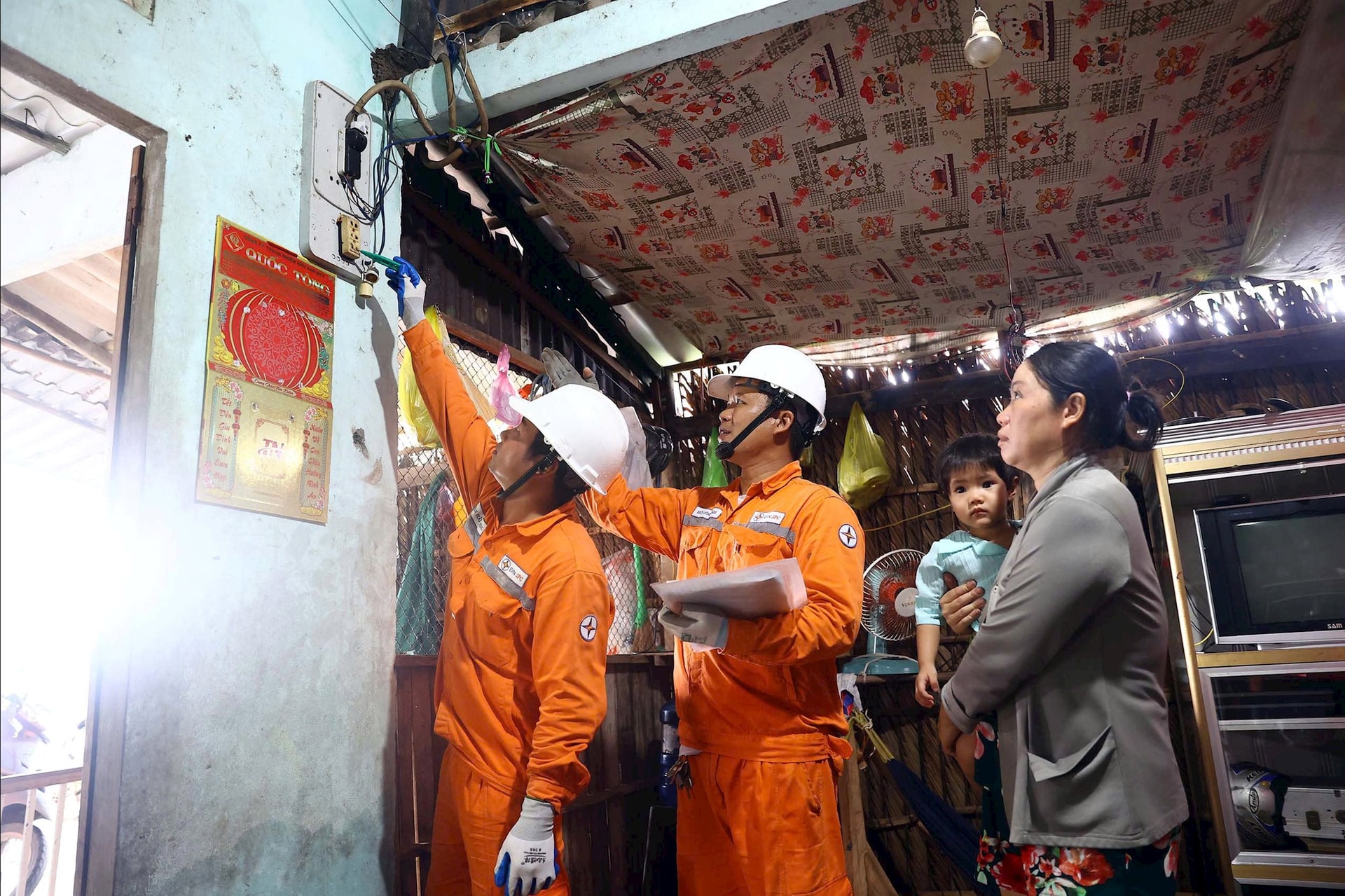 Công nhân Công ty Điện lực Cà Mau kiểm tra, hướng dẫn các hộ gia đình sử dụng điện sau công tơ - Ảnh: EVNSPC