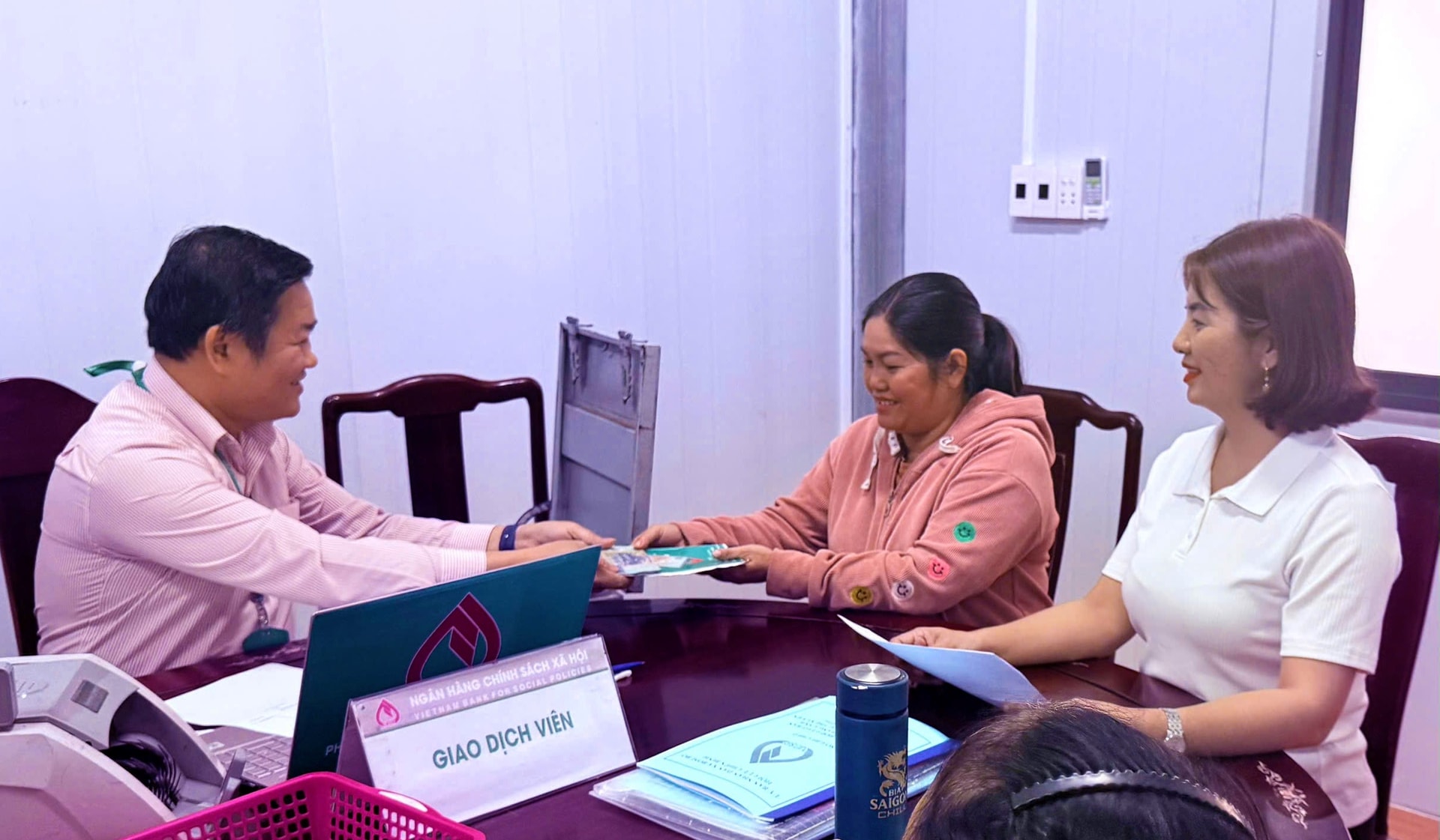 Cán bộ ngân hàng giải ngân vốn vay cho người đồng bào dân tộc S' tiêng làm ăn, phát triển kinh tế