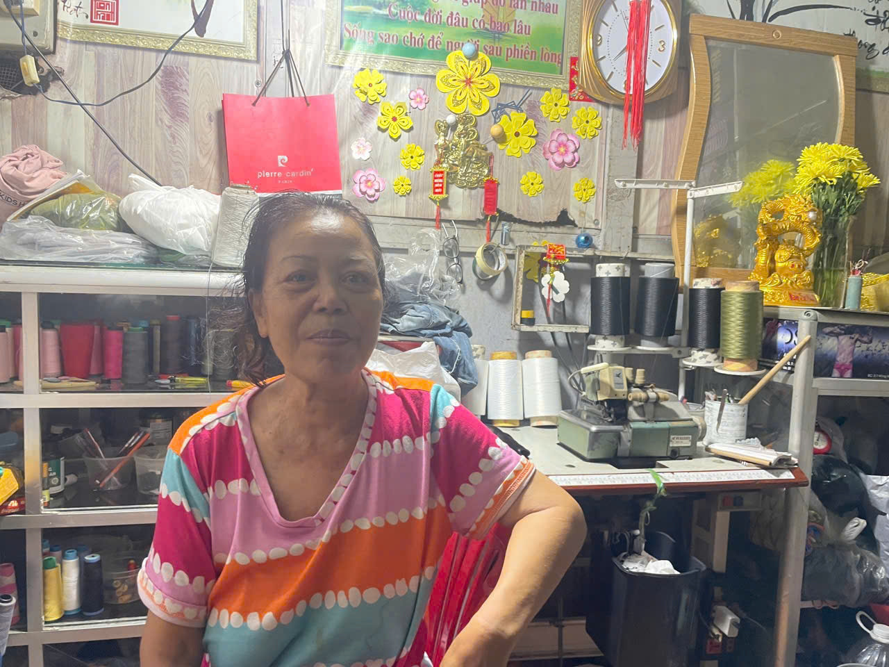 Bà Trương Thanh Hóa làm nghề sửa quần áo cũ tại chợ Văn Thánh hiện đang lâm bệnh nhưng vẫn ngày ngày nhặt nhạnh từng đồng tiền công còm cõi. Ảnh: Nguyễn Tuyết. 