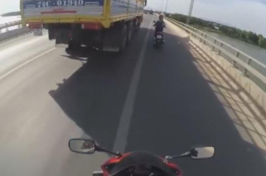 Clip cô gái chạy xe máy sát bên xe tải để tránh nắng
