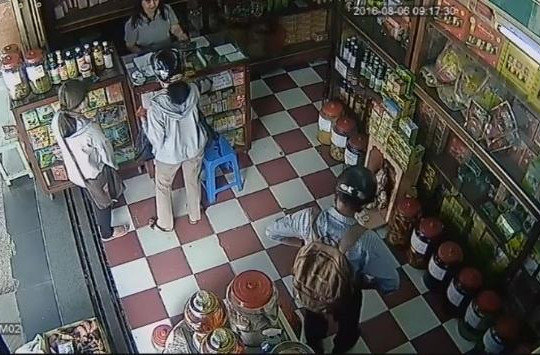 Người đàn ông mặc lịch sự trộm túi xách trong cửa hàng bán atiso