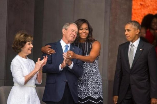 Bà Obama ôm chầm cựu Tổng thống Bush trước mặt chồng