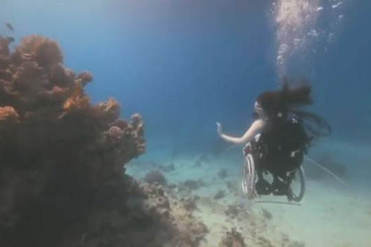 Người phụ nữ bị liệt lặn biển trên chiếc xe lăn