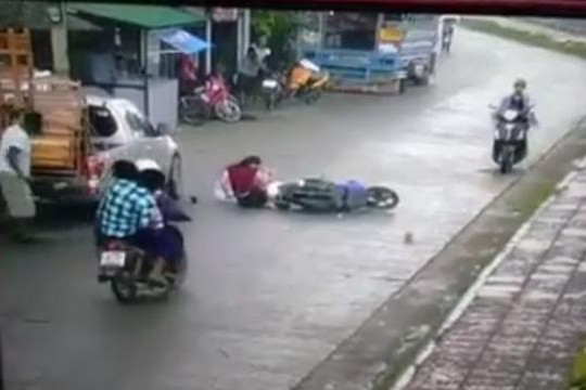 Vừa lái xe máy vừa che dù, cô gái đâm thẳng vào đuôi ô tô