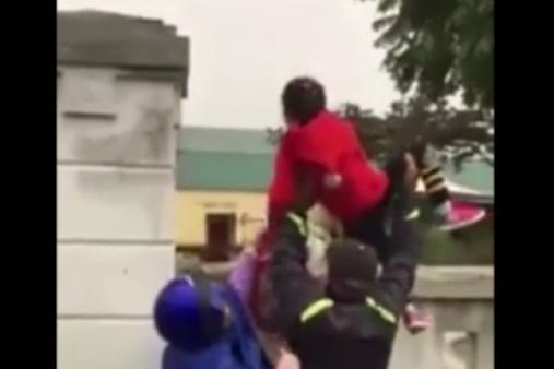 Video: Trường đóng cổng trong giá rét, phụ huynh bế chuyền con qua tường rào