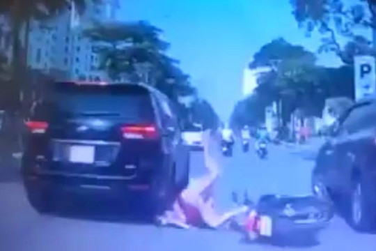 Clip mẹ địu con chạy xe bất cẩn, té lao đầu vào bánh ô tô ở Hà Nội