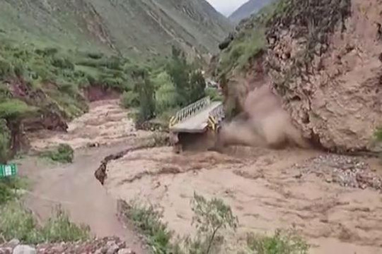 Hãi hùng cảnh nước lũ đẩy sập vách đá, cuốn phăng cầu tại Peru