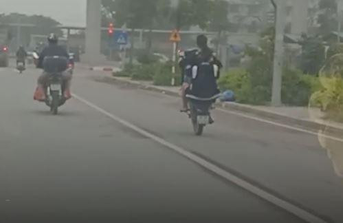 Hai thanh niên không đội mũ bảo hiểm bốc đầu xe máy trên đường