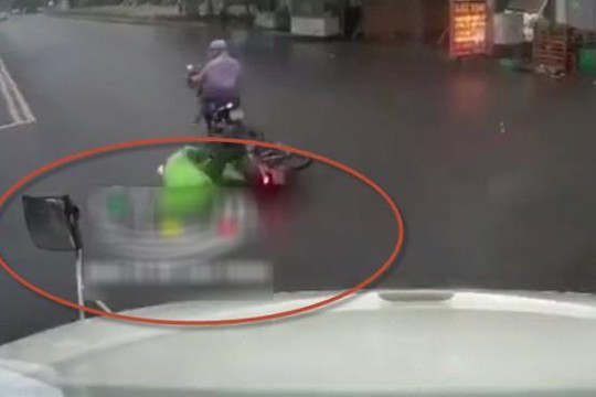 Clip người đi xe máy vượt đèn đỏ té ra đường, nằm la khóc dưới bánh container