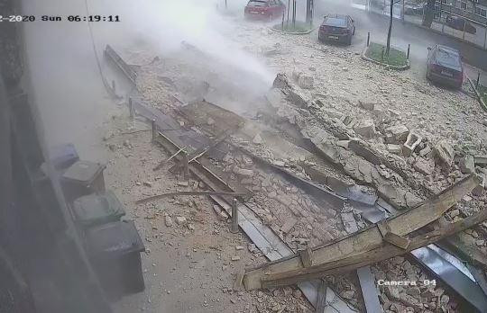 Động đất làm mảng tường rơi xuống đường, ô tô thoát nạn trong gang tấc