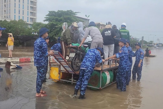 Cảnh sát biển ngâm mình trong nước hỗ trợ người dân vượt điểm ngập sâu trên Quốc lộ 70