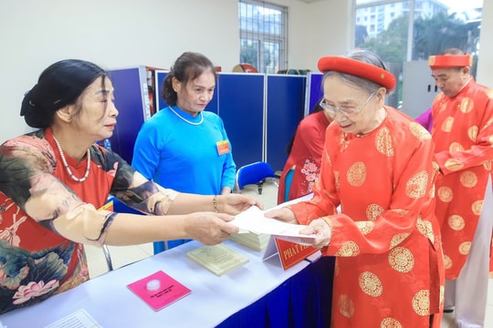 Các cụ ông, cụ bà mặc áo dài đỏ, đội khăn xếp đi bầu cử